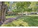 Landscaped front yard featuring a lush lawn, mature trees, and a ranch-style home at 5841 N Parker Ave, Indianapolis, IN 46220