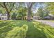 Beautifully landscaped front yard with large trees shading a charming ranch-style home at 5841 N Parker Ave, Indianapolis, IN 46220