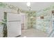 Bright kitchen offers white appliances, and floral wallpaper, adding a retro flair at 5841 N Parker Ave, Indianapolis, IN 46220