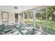 Enclosed sunroom with large windows overlooking the landscaped yard and mature trees at 5841 N Parker Ave, Indianapolis, IN 46220