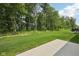Beautiful green yard surrounded by trees, with a sunny sky overhead and a concrete patio at 624 Faudree Dr, Westfield, IN 46074