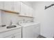 Bright laundry room features white cabinets, utility sink, and modern washer and dryer at 624 Faudree Dr, Westfield, IN 46074