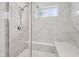 The marble shower has a built in seat and glass enclosure, with bright light from a small window at 624 Faudree Dr, Westfield, IN 46074