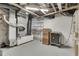 Unfinished basement utility area with furnace, shelving, wooden cabinet, and safe at 629 S Miller St, Shelbyville, IN 46176