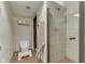 Clean bathroom featuring a beige tile shower and toilet with a step stool at 629 S Miller St, Shelbyville, IN 46176