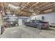 Spacious garage with storage, a car, and exposed rafters, offering ample parking and storage at 629 S Miller St, Shelbyville, IN 46176