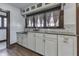 The kitchen has white cabinetry and lots of natural light coming from the large window at 629 S Miller St, Shelbyville, IN 46176