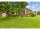 Attractive brick home with a well-kept front yard, mature landscaping, and charming window shutters at 6629 Woodcrest Dr, Avon, IN 46123