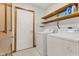 Bright laundry room features white washer and dryer with shelving, with neutral tile flooring at 6629 Woodcrest Dr, Avon, IN 46123