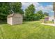 Well-maintained backyard featuring a storage shed, patio, and green lawn at 6635 Blackthorn Dr, Indianapolis, IN 46221