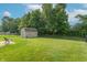 Beautiful backyard with green lawn, storage shed, patio, and chain link fence at 6635 Blackthorn Dr, Indianapolis, IN 46221