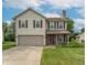 Inviting two-story home with a classic facade, attached garage, and a lovely front yard at 6635 Blackthorn Dr, Indianapolis, IN 46221