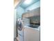 Efficient laundry room featuring front loading washer/dryer and storage cabinets at 6635 Blackthorn Dr, Indianapolis, IN 46221