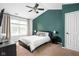 Comfortable bedroom featuring a ceiling fan, a large window, and a modern dark green accent wall at 6637 Sundown S Dr, Indianapolis, IN 46254
