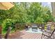 Outdoor deck with wood furniture, a rug, and a partial umbrella, surrounded by lush greenery at 6637 Sundown S Dr, Indianapolis, IN 46254