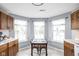 Sunlit dining area featuring wood cabinets, tile floors, and three large windows at 6637 Sundown S Dr, Indianapolis, IN 46254