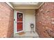 Charming entryway with brick walls, decorative wreath on the red door, and a lovely flower arrangement at 6637 Sundown S Dr, Indianapolis, IN 46254