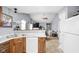 Open-concept kitchen with wood cabinets, white appliances, and a view into the living area at 6637 Sundown S Dr, Indianapolis, IN 46254
