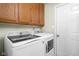 Laundry area with newer front load washer and dryer, oak cabinets, and light neutral walls at 6637 Sundown S Dr, Indianapolis, IN 46254