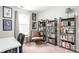 Well-lit office space with floor-to-ceiling bookshelves, a comfortable chair, and natural light at 6637 Sundown S Dr, Indianapolis, IN 46254