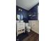 Stylish bathroom with blue walls, white wainscoting, gold fixtures, and dark wood floors at 6842 Arrowhead Dr, Brownsburg, IN 46112