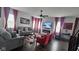 Bright living room with hardwood floors, gray sofas, red accents, and a modern fireplace at 6842 Arrowhead Dr, Brownsburg, IN 46112