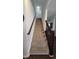 Carpeted staircase with dark wood railing and white walls at 6842 Arrowhead Dr, Brownsburg, IN 46112