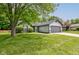Well-manicured front lawn with mature trees compliments this home with a two car garage at 7239 Wet Rock Ct, Indianapolis, IN 46236