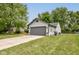 Side view of a two-car garage with gray door, siding, and driveway, surrounded by lawn and trees at 7239 Wet Rock Ct, Indianapolis, IN 46236