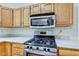 Modern kitchen features stainless steel stove, microwave, and ample oak cabinetry at 7239 Wet Rock Ct, Indianapolis, IN 46236
