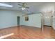 Open-concept living room with hardwood floors, skylight, fan, and access to kitchen at 7239 Wet Rock Ct, Indianapolis, IN 46236