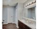 Bathroom featuring a double sink vanity with dark cabinets and modern fixtures, plus a white door at 7372 Oakview Dr, Avon, IN 46123