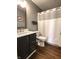 Cozy bathroom featuring hard wood floors, wood vanity with updated sink, and a shower-tub combo at 7470 Charrington Ct, Indianapolis, IN 46254