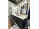 Modern bathroom vanity with dual sinks, decorative lighting, and a large framed mirror at 7470 Charrington Ct, Indianapolis, IN 46254