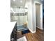 Modern bathroom with glass enclosed shower featuring mosaic tiling, hard wood floors and new fixtures at 7470 Charrington Ct, Indianapolis, IN 46254