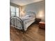 Comfortable bedroom with a metal framed bed, plush bedding, and a dark wood bedside table at 7470 Charrington Ct, Indianapolis, IN 46254