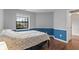 Bright bedroom featuring laminate floors and natural light from the window at 7616 Derrek Pl, Indianapolis, IN 46219