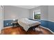 Bedroom with natural light, beautiful floors, and a navy accent wall at 7616 Derrek Pl, Indianapolis, IN 46219