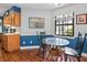 Bright dining area with a glass table, wood chairs, wainscoting, hardwood floors, and a view of the kitchen at 7616 Derrek Pl, Indianapolis, IN 46219