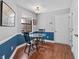 Cozy dining area with a glass table, wood chairs, wainscoting, hardwood floors, and natural light at 7616 Derrek Pl, Indianapolis, IN 46219