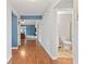 Bright hallway featuring hardwood floors and a bathroom with toilet at 7616 Derrek Pl, Indianapolis, IN 46219