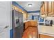 Traditional kitchen features wood cabinets, stainless steel appliances, white countertops, and hardwood floors at 7616 Derrek Pl, Indianapolis, IN 46219