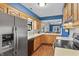 Traditional kitchen features wood cabinets, white countertops, stainless steel appliances, and hardwood floors at 7616 Derrek Pl, Indianapolis, IN 46219