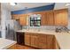 Traditional kitchen features wood cabinets, white countertops, stainless steel fridge, and hardwood floors at 7616 Derrek Pl, Indianapolis, IN 46219