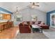 Inviting living room boasts vaulted ceilings, fan, updated windows, and stylish modern furniture at 7616 Derrek Pl, Indianapolis, IN 46219