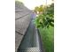 Close-up of a well-maintained roof and gutter system, highlighted by green foliage and a neatly kept lawn at 7616 Derrek Pl, Indianapolis, IN 46219