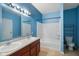 Bathroom with double sinks and blue walls and shower/tub combo at 7715 Bolero Dr, Camby, IN 46113