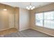 A bright dining room features gray carpet, a large window, and modern chandelier lighting at 7715 Bolero Dr, Camby, IN 46113