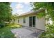 View of backyard concrete patio with sliding door, windows, and lush landscaping at 779 Alvey Ct, Greenwood, IN 46143