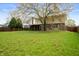 Well maintained backyard with mature tree coverage, lawn, and covered porch at 8306 Corkwood Dr, Indianapolis, IN 46227